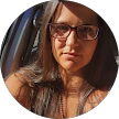 A woman with long hair and glasses featured in her Google reviewer profile picture