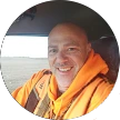 A man wearing an orange high-visibility jacket featured in his Google reviewer profile picture