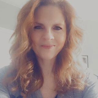 business owner Kimberly Ciucci smiling with wavy hair.