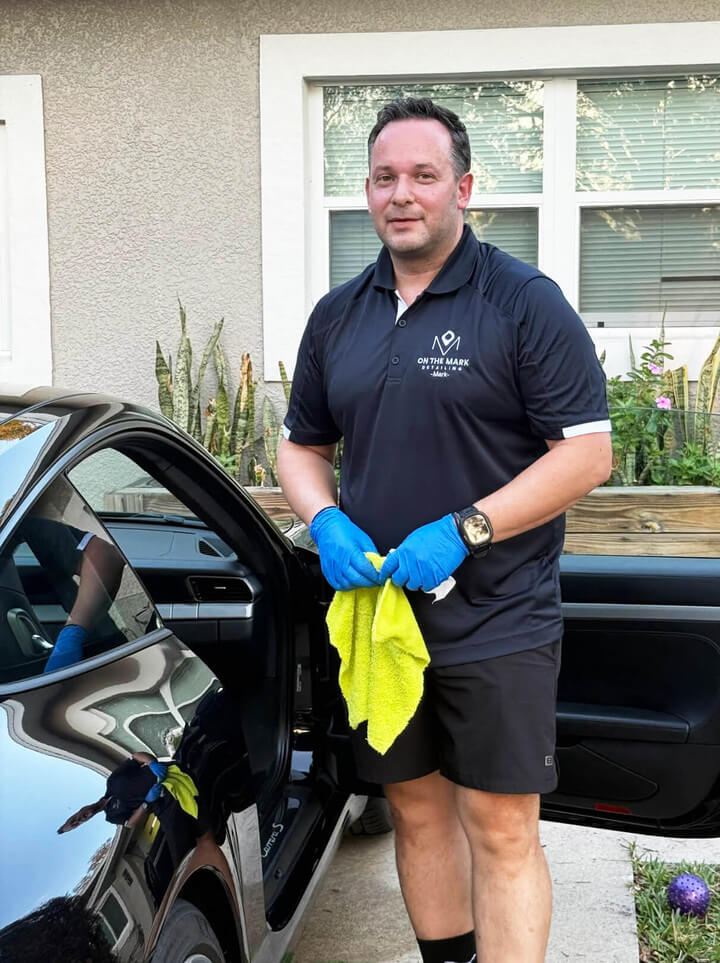 business owner Mark Rigas wearing gloves while working on a car.