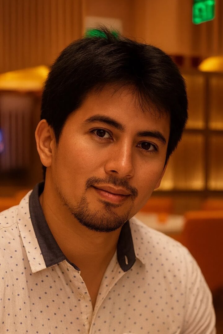 business owner Paolo Godinez in a casual shirt, smiling in warm lighting.