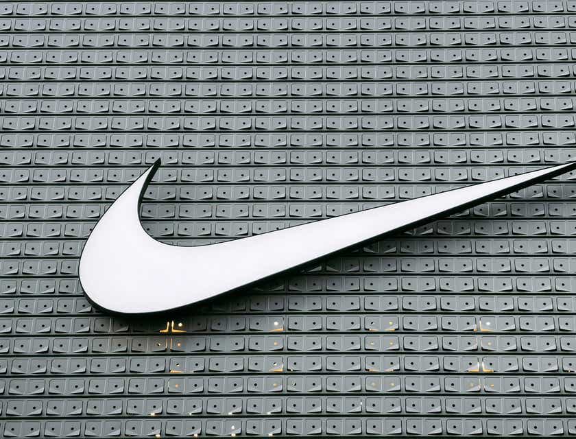 Logotipo de la marca Nike en color blanco sobre un fondo gris de apariencia metálica.