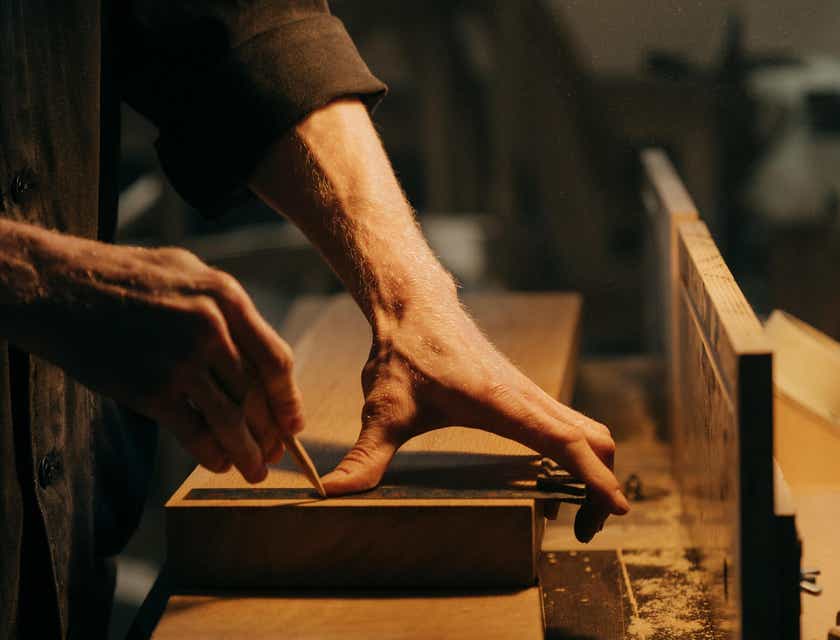 Un charpentier entrain de faire des mesures sur une planche de bois.