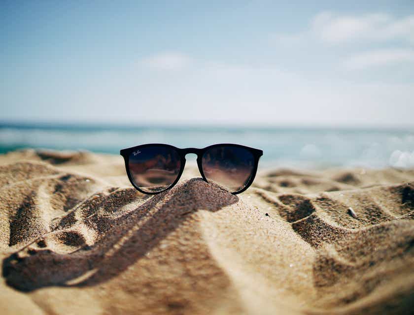 Okulary przeciwsłoneczne położone na piasku na plaży.