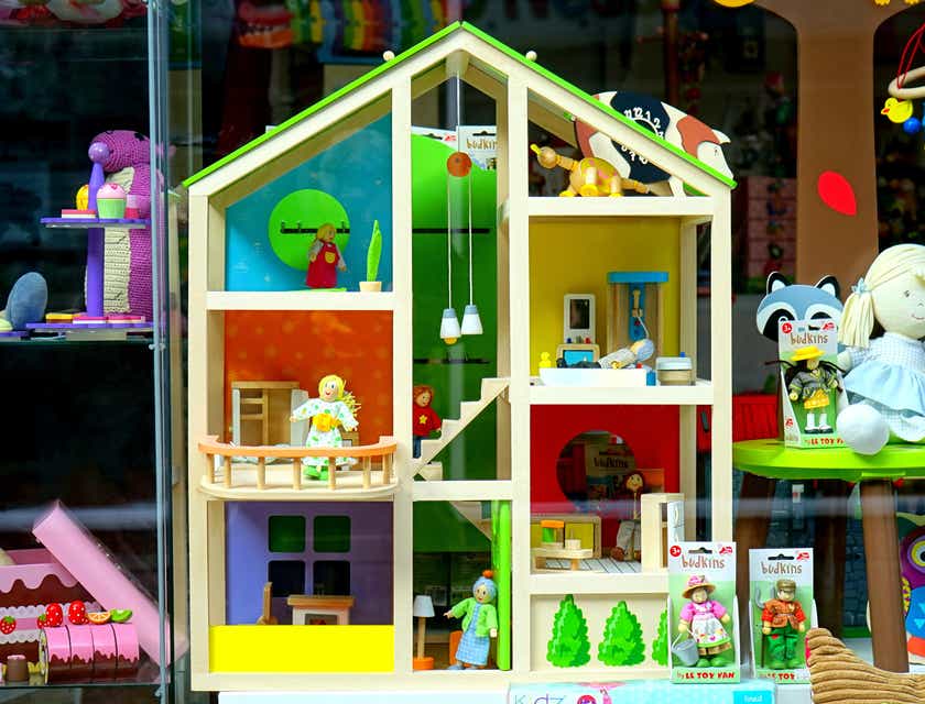 Domek dla lalek i maskotki zaprezentowane w witrynie sklepu z zabawkami.