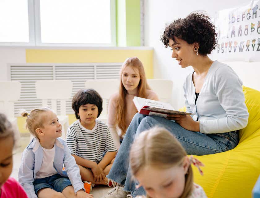 Un profesor leyendo un libro escolar en un jardín de niños.