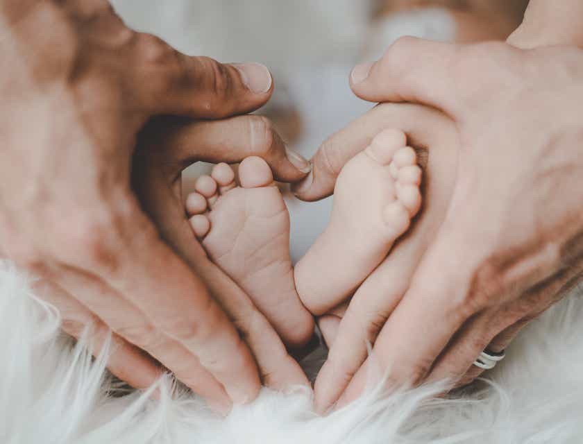 Een moeder en vader die de voeten van hun baby vasthouden.