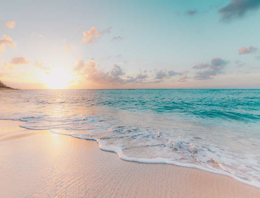 Bir sahildeki gün batımını gösteren plaj temalı bir görsel.