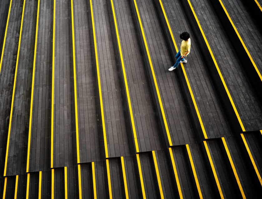 Una persona che cammina su delle scale nere e gialle.