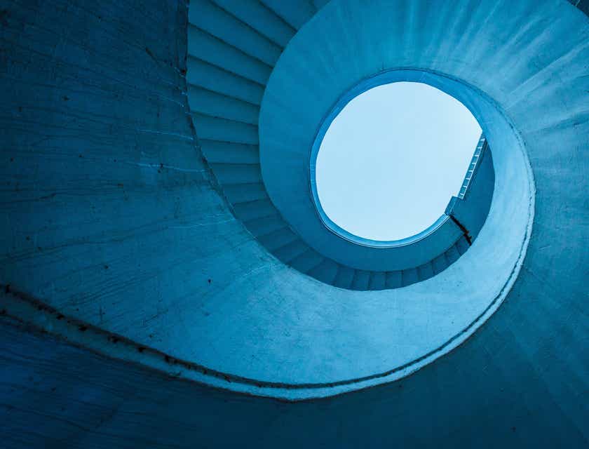 Una scala a spirale blu — o elicoidale — vista dal basso.