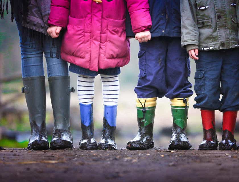 Een groep kinderen met laarzen in de modder.