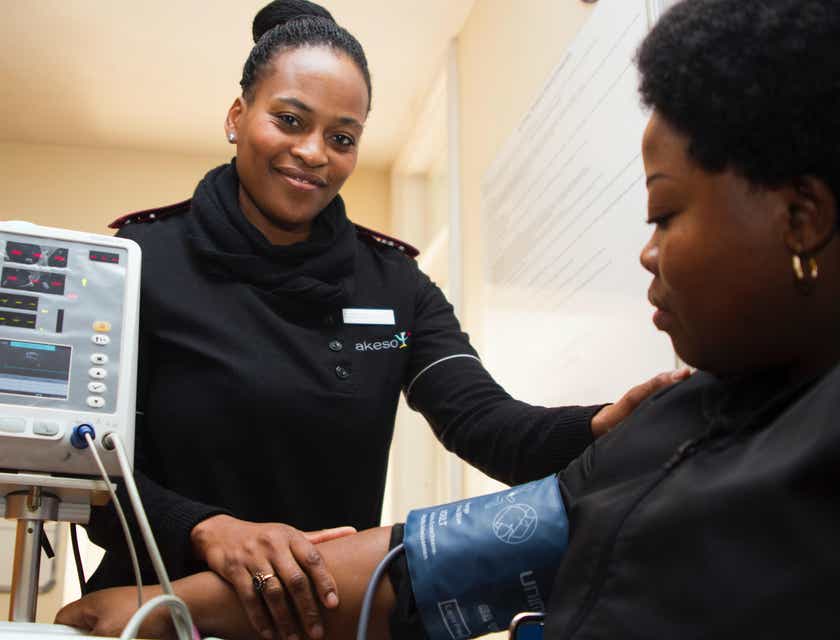 Un'infermiera che misura la pressione a una paziente in una clinica.