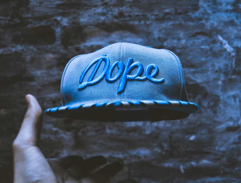 Um boné azul com a palavra em inglês "dope", que significa "irado", estampada nele.