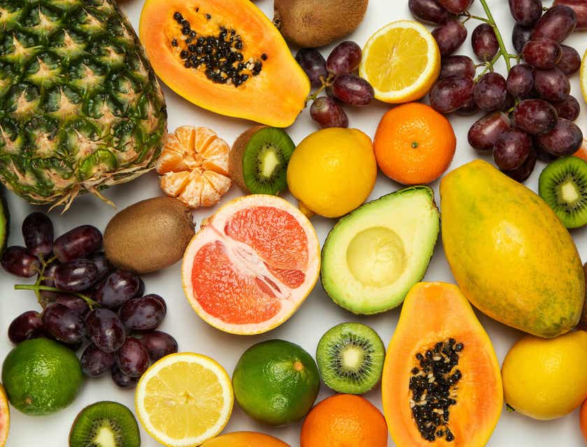 Una gran variedad de fruta fresca expuesta en un fondo blanco en un logo de frutas.