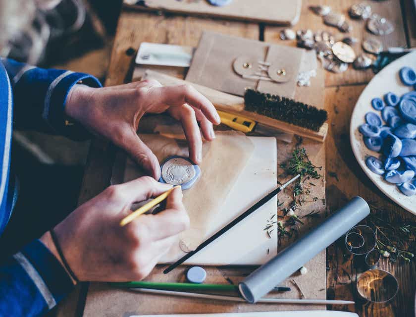 Una persona que elabora una pieza de joyería hecha a mano en un logo artesanal.