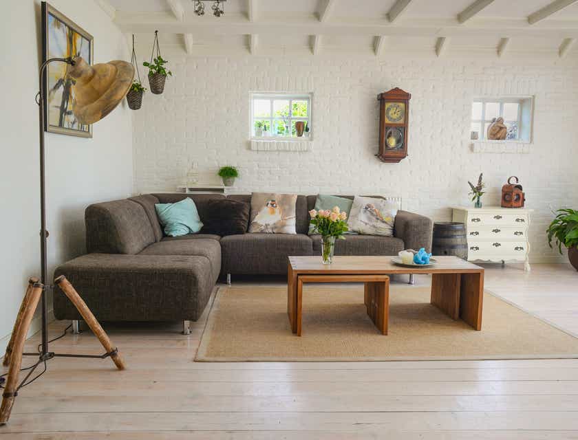 Un canapé sectionnel marron contre un mur avec une table basse, de la lumière et des ornements autour de lui mis en place dans un magasin de meubles pour la maison.