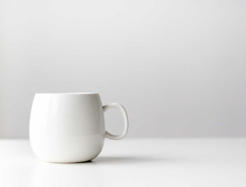 Sebuah cangkir keramik putih minimalis dengan latar belakang putih.