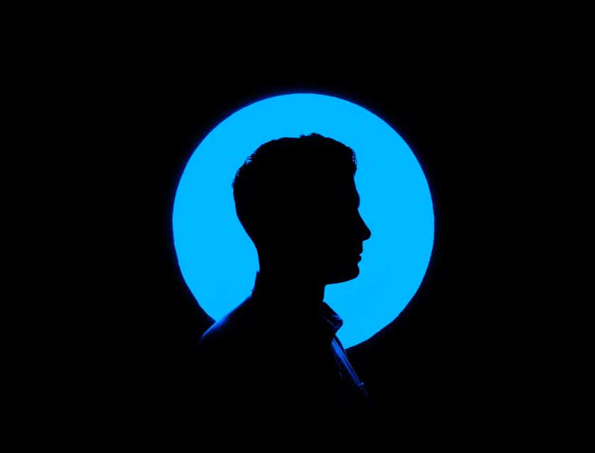La silueta de un hombre que forma un espacio negativo con la luz azul de fondo.