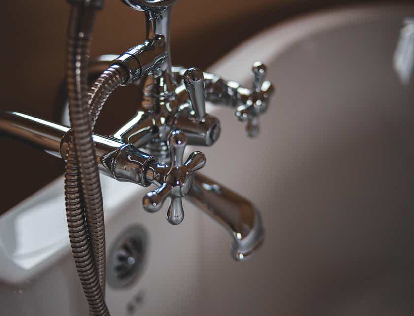 Des travaux de plomberie effectués sur un robinet de baignoire chromé.