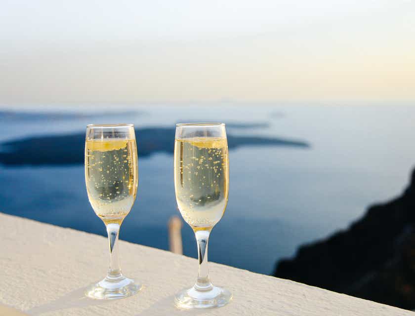 Due calici di champagne sul bordo di un balcone in un hotel raffinato con vista sul mare.