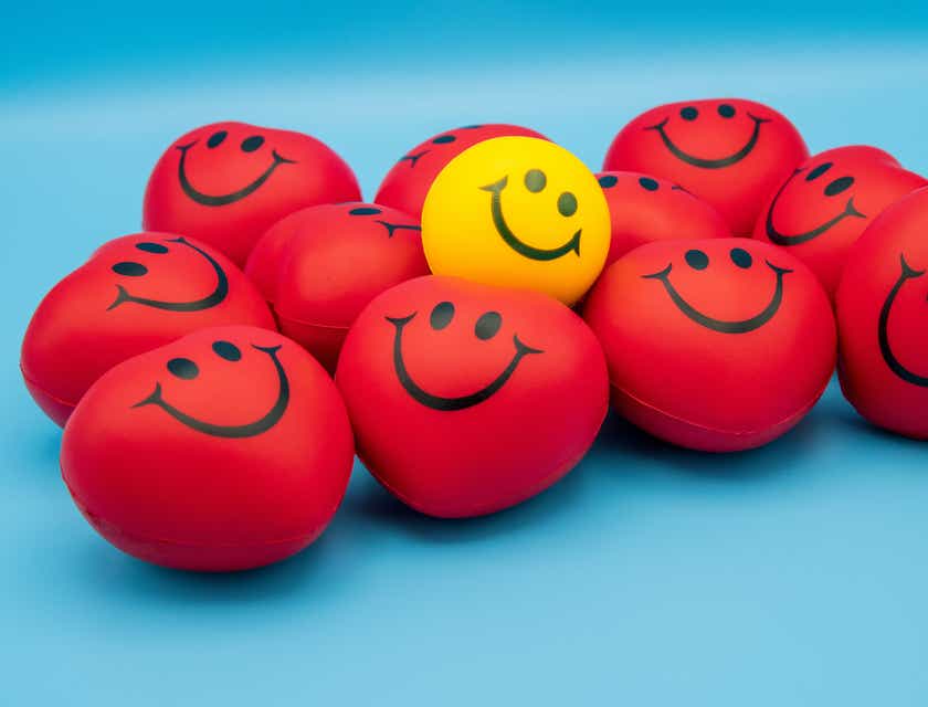 Rote und gelbe Smileys liegen auf einer blauen Oberfläche.