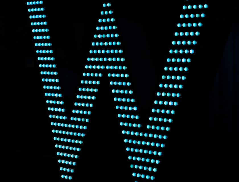 Litera „W” stworzona z błękitnych świateł LED lśniących ciemnego tła.
