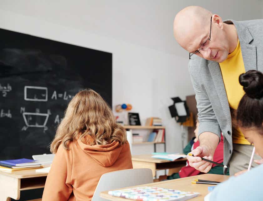 Educador enseñando a sus jóvenes alumnos en un aula en un negocio educativo.