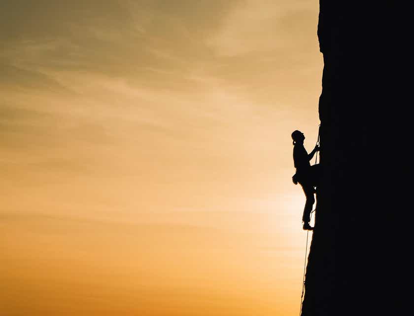 Una persona ambiziosa che sta scalando una montagna per raggiungere la vetta.