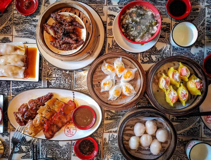 Divers plats asiatiques servis dans des assiettes en céramique blanche dans un restaurant asiatique.