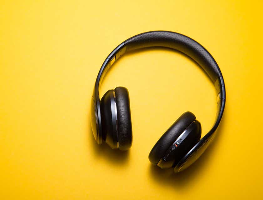 Auriculares de audio inalámbricos en una superficie amarilla en un logo para audio.