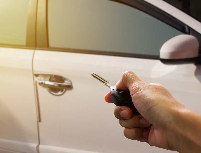 A person remotely locking their car with a vehicle security system.