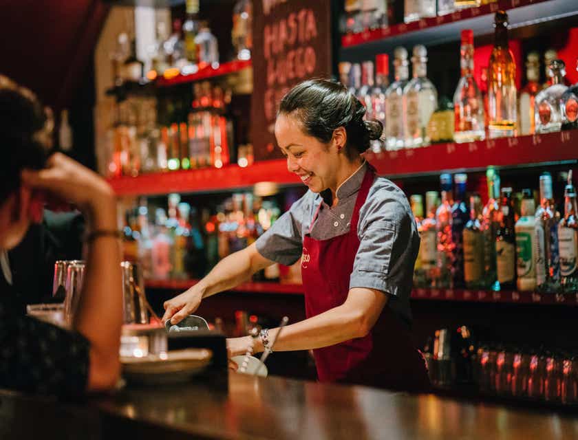 A bartender mixing drinks at a snazzy bar.