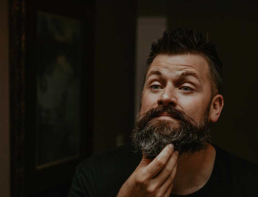 Un uomo che mette dell’olio da barba nella sua barba.