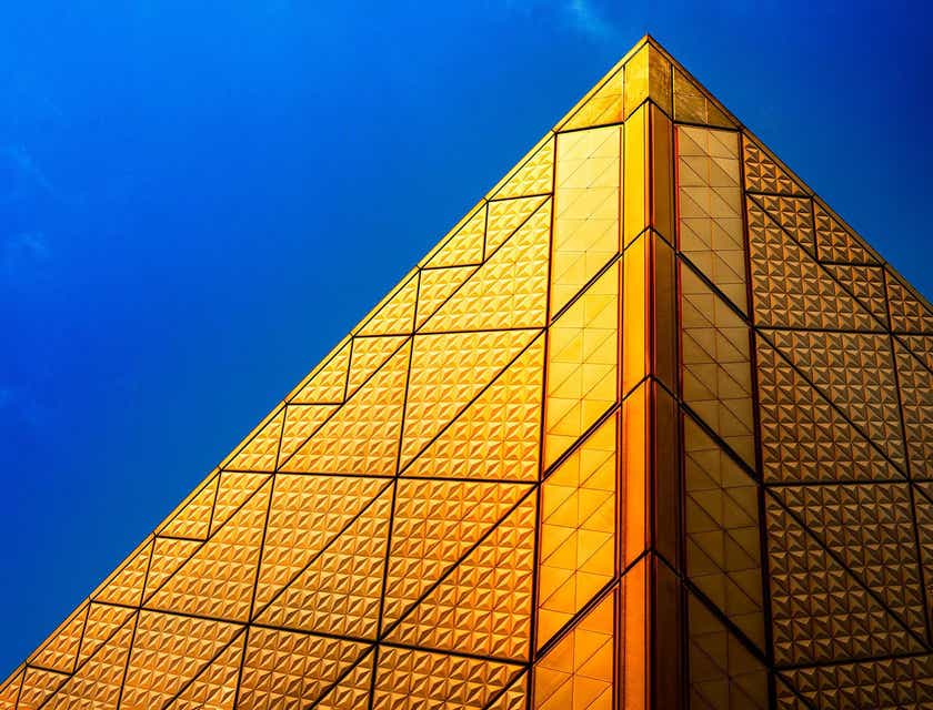 Een goudkleurige piramide tegen een blauwe lucht.