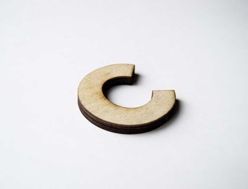 A wooden letter C displayed against a white background.