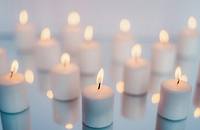 Tea light candles on a reflective surface.