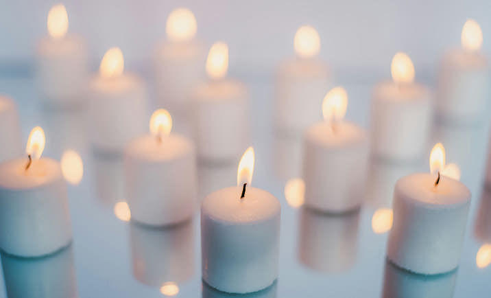 Tea light candles on a reflective surface.