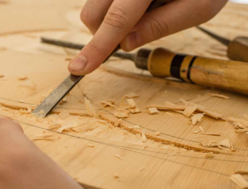 Um carpinteiro entalhando madeira em uma carpintaria.