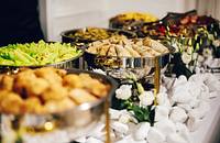 A buffet table with various food dishes set up by a catering company.
