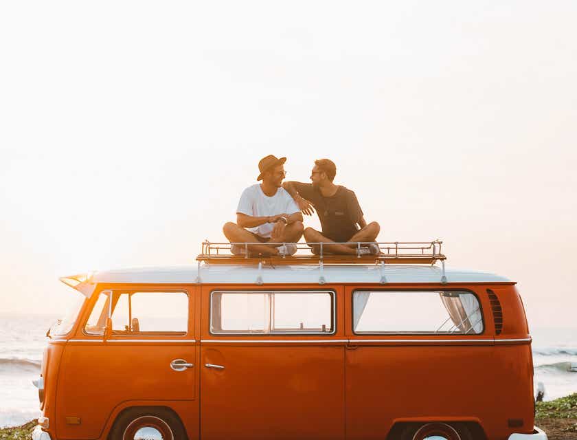 Deux personnes relaxées assises sur le toit d'un camping-car.