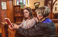 A pastor helping a church member interpret a bible passage.