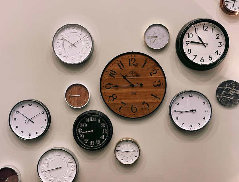 A variety of clocks mounted on a wall.
