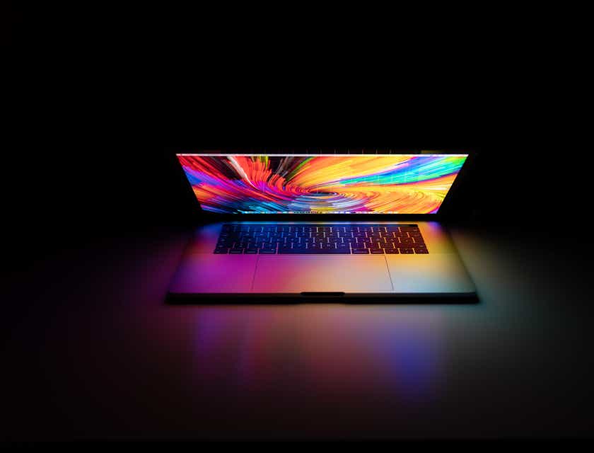Um MacBook Pro ligado em uma sala escura.