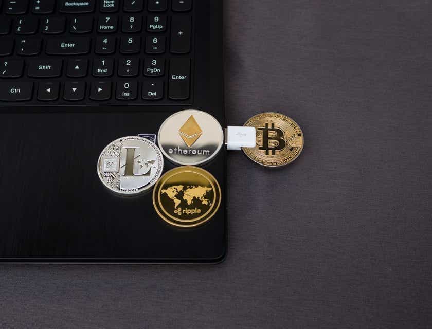 Koin yang menggambarkan berbagai mata uang crypto di laptop.