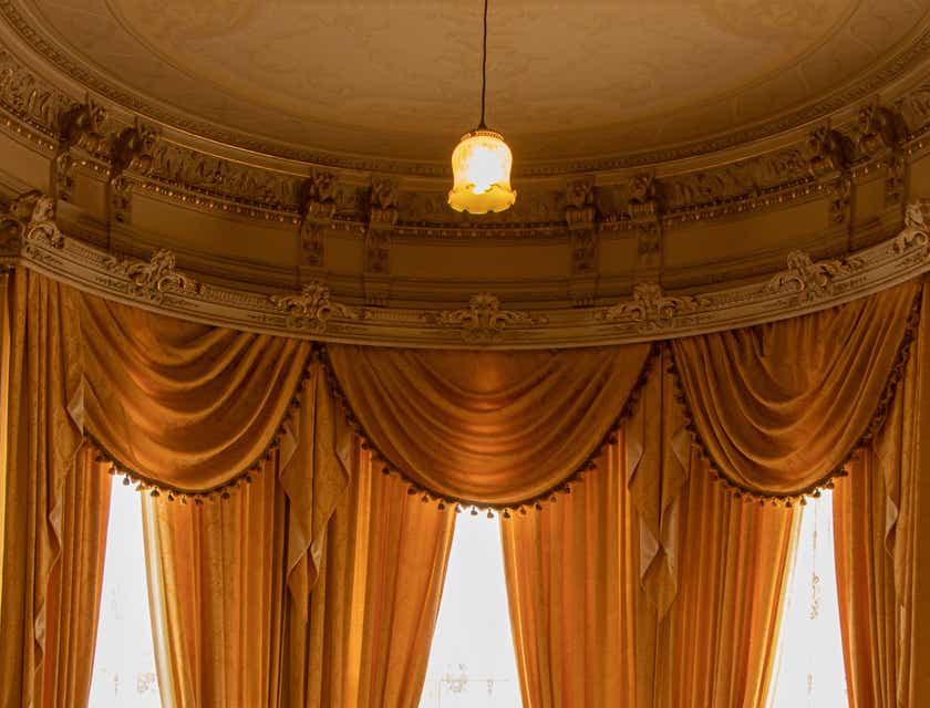Curtains and drapes covering large bay windows in the drawing room of a house.