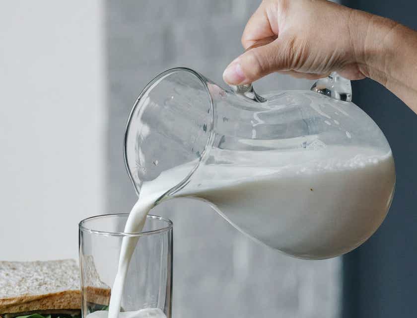 Envases de cristal llenos de leche en un logo para lácteos.