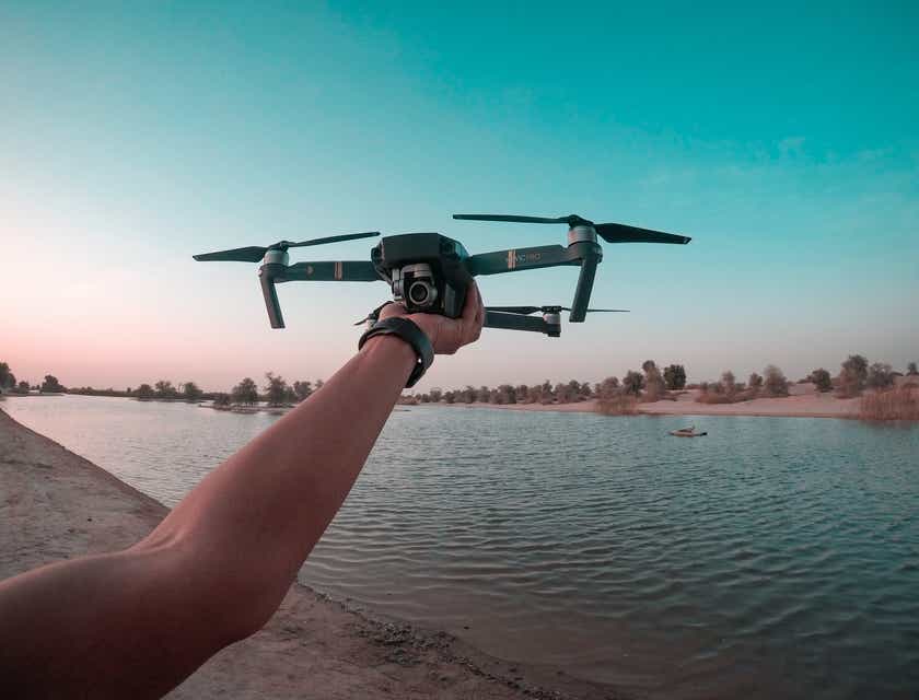 Une personne s'apprête à lancer un drone pour prendre des photos par drone d'un lac.