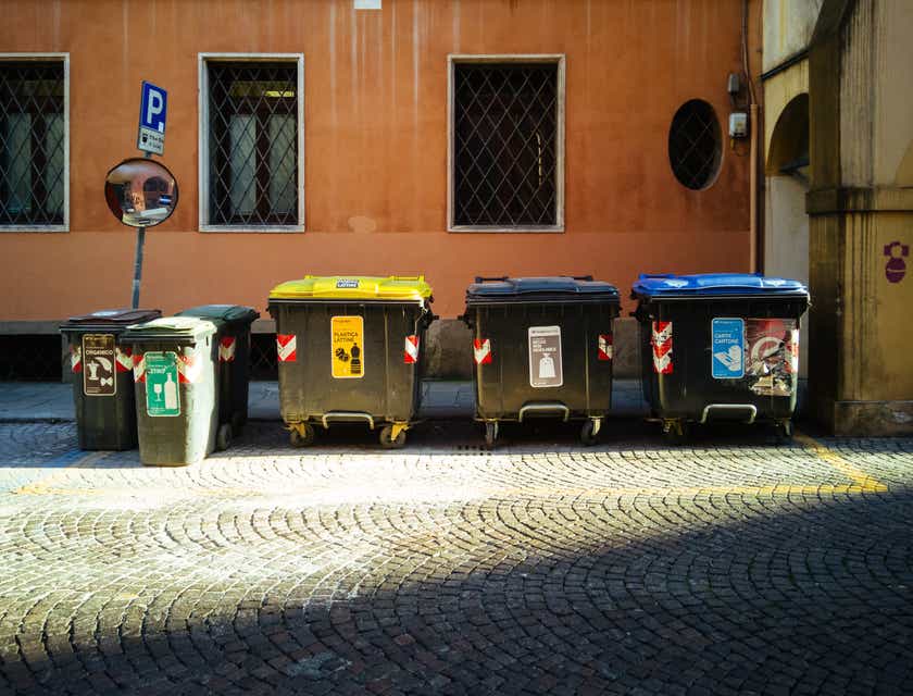 Bir apartmanın önünde sıralanmış bir dizi çöp konteyneri.