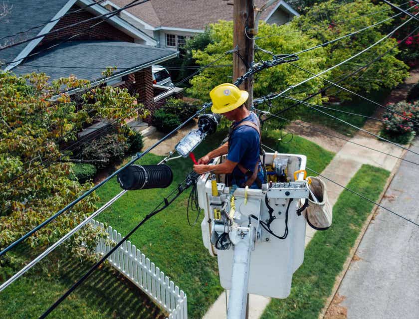 Eletricista fazendo manutenção de cabos elétricos.