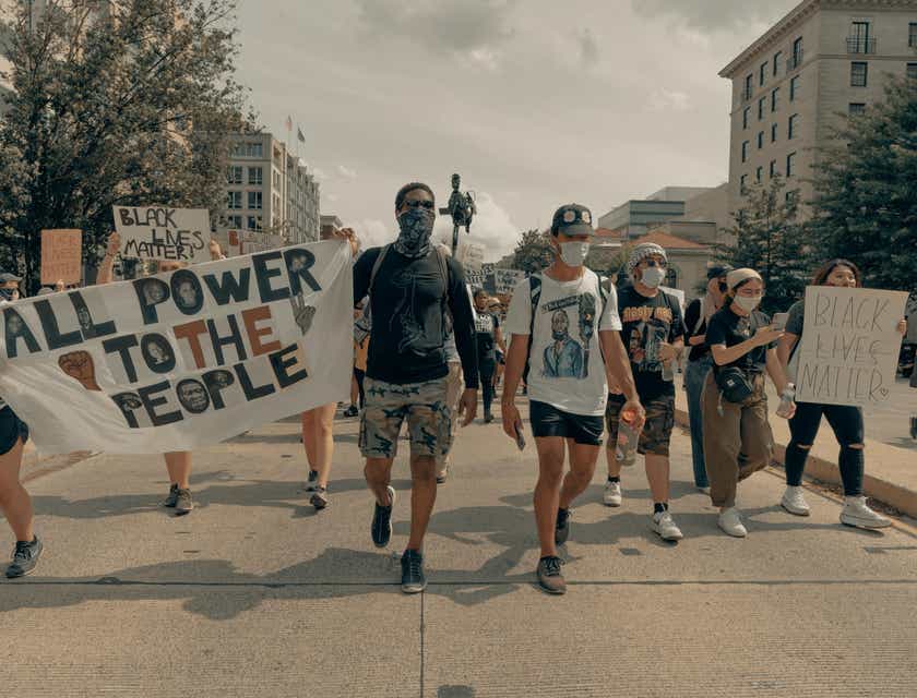 Un grupo de personas marchando y sosteniendo letreros con mensajes empoderados.